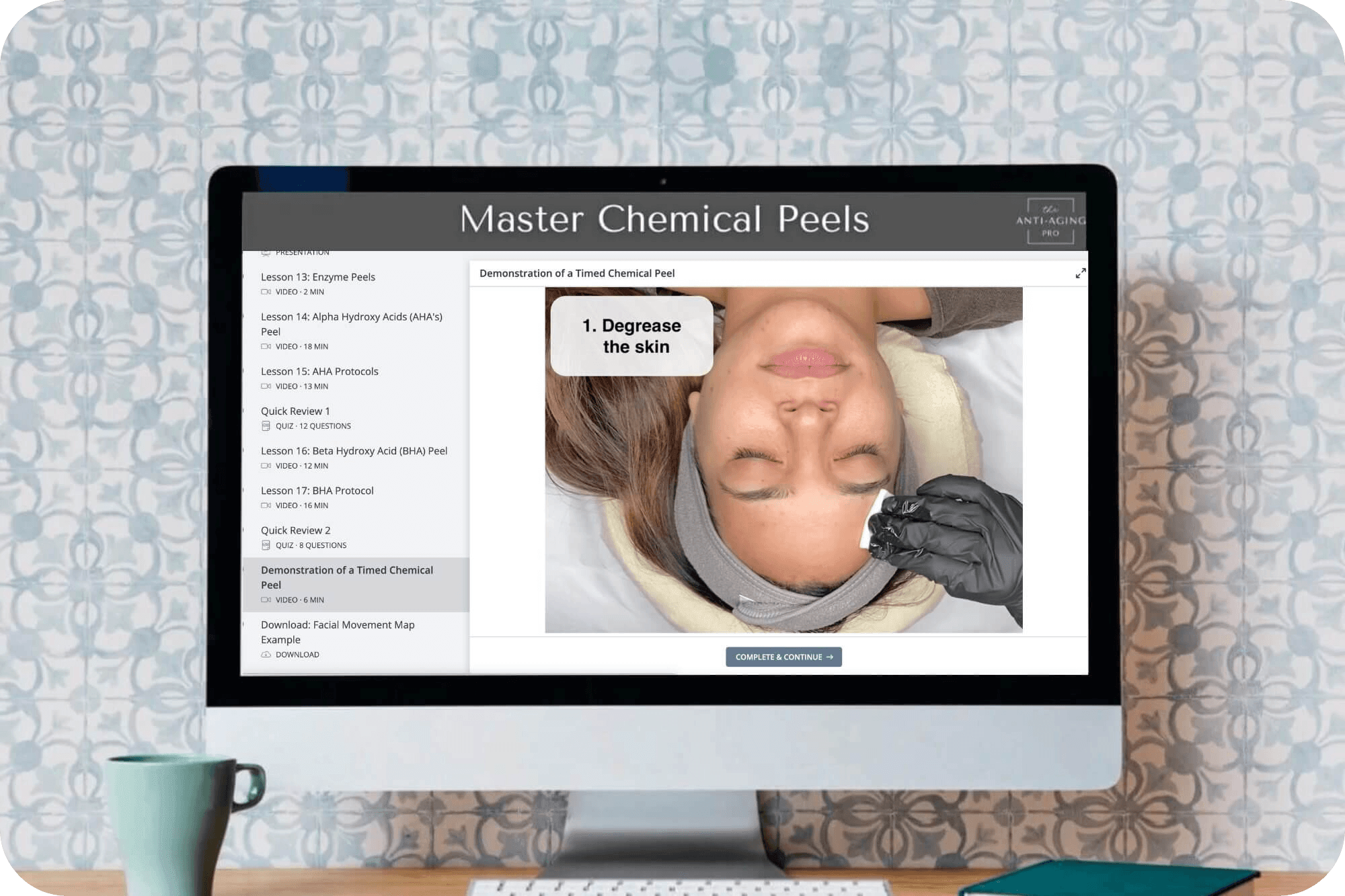 Computer screen displaying a tutorial on chemical peels with a cup and notebook on a desk.